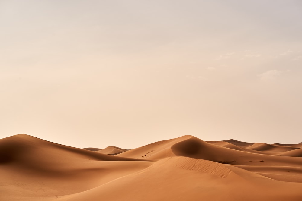 a group of sand dunes with a sky background