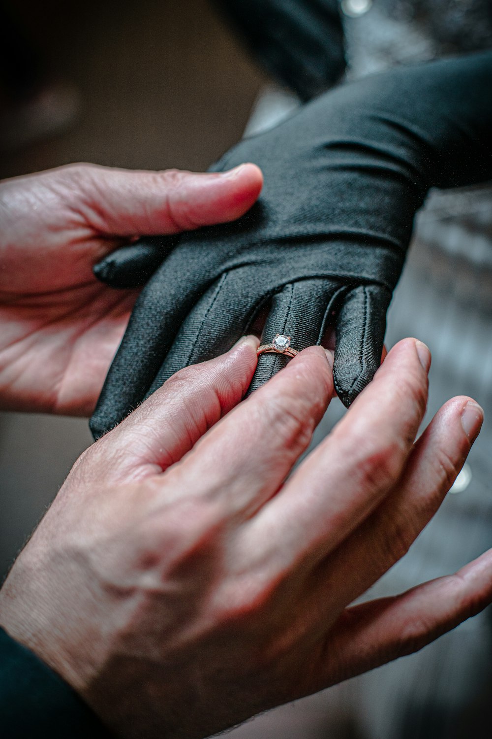 a person wearing a ring and a black glove