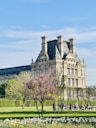 a large building with a lot of flowers in front of it