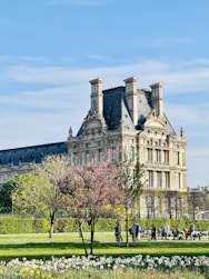 a large building with a lot of flowers in front of it