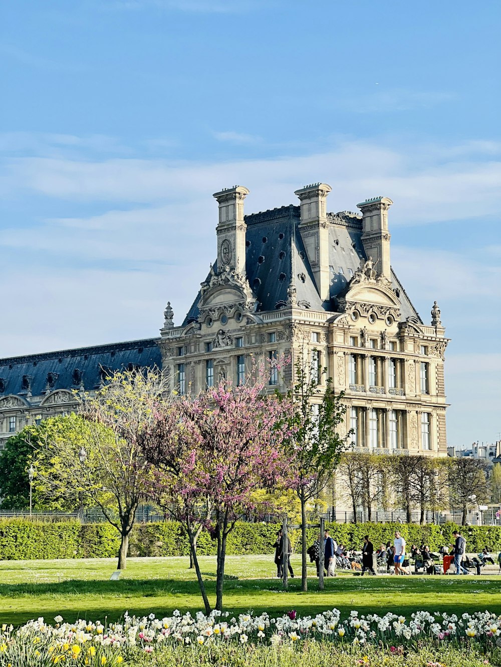 a large building with a lot of flowers in front of it