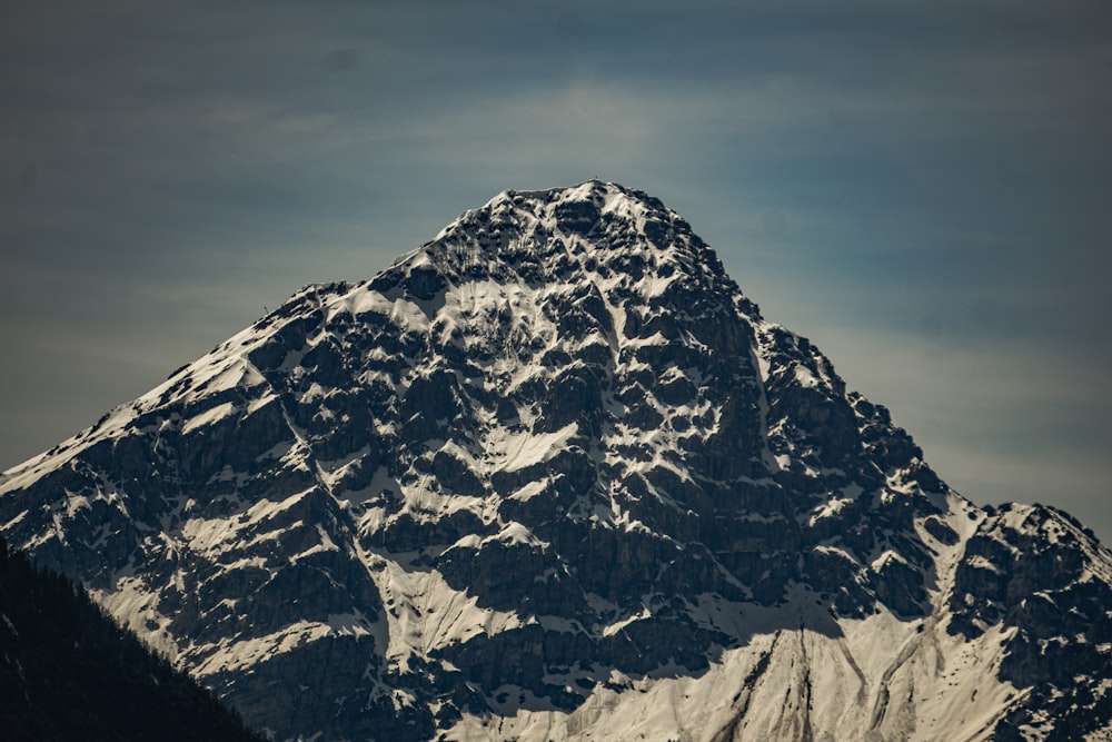 a large snow covered mountain with a sky background
