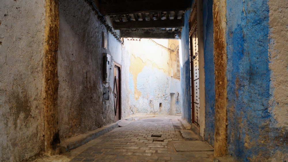a narrow alley way with blue and white walls