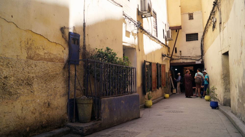 a group of people walking down a narrow alley way