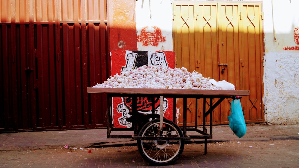 a cart full of food sitting on the side of a road