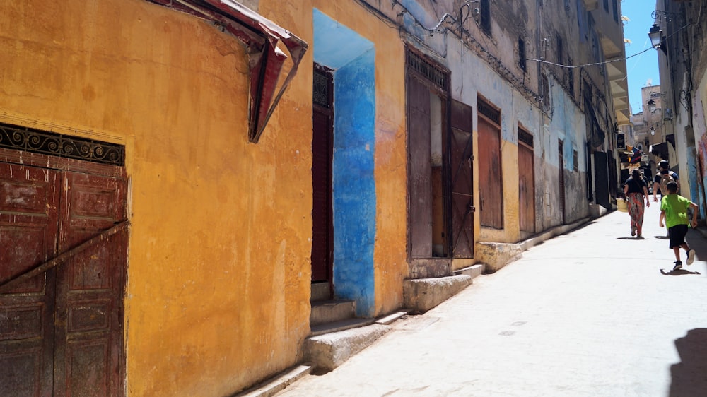 a narrow street with people walking down it