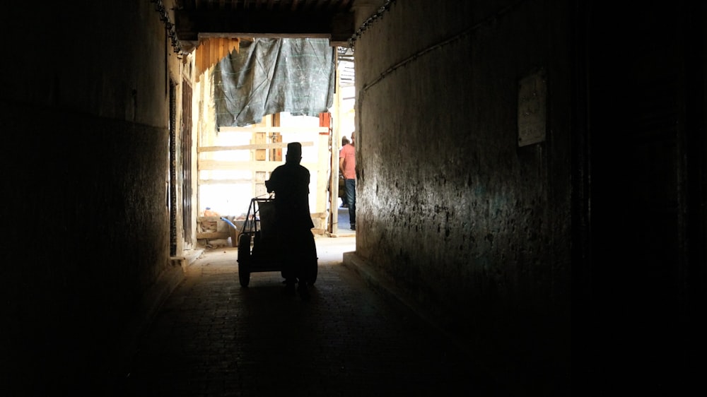 a person pushing a cart through a dark tunnel