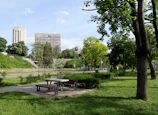 A peaceful picnic spot with benches and a backdrop of leafy trees inside the park.