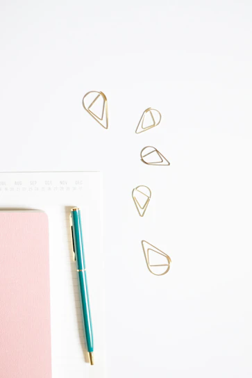 Colorful notebooks and planners arranged on a clean white desk with subtle circular design elements in the background