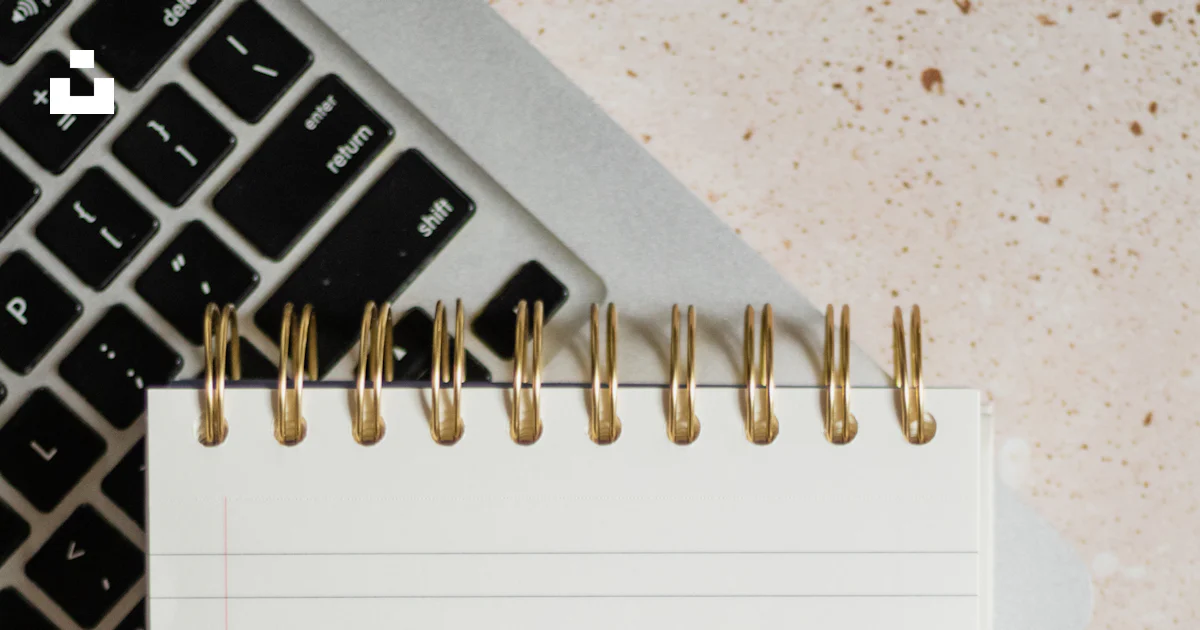 A notepad sitting on top of a laptop computer next to a keyboard photo ...