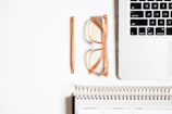 A serene workspace with a laptop, soft pink accents, and a neatly organized planner ready for the day.