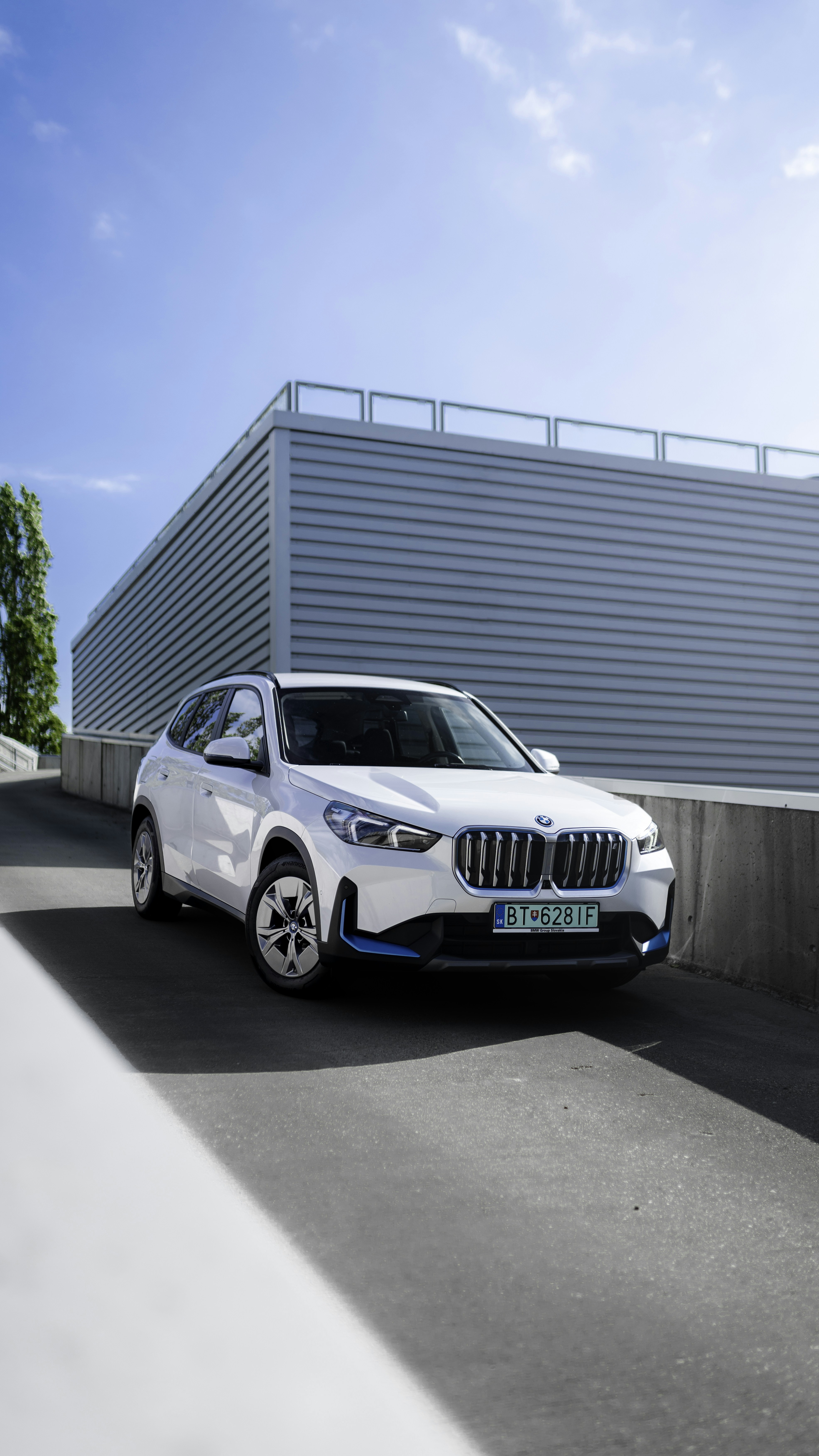 White electric SUV on a highway with clear blue sky, modern design with LED light bar