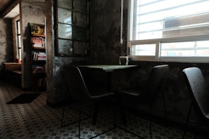 A quiet corner with a comfortable chair, a small bookshelf, and a window overlooking a peaceful garden.