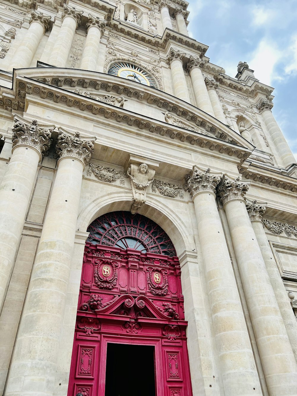 uma porta vermelha está em frente a um prédio alto