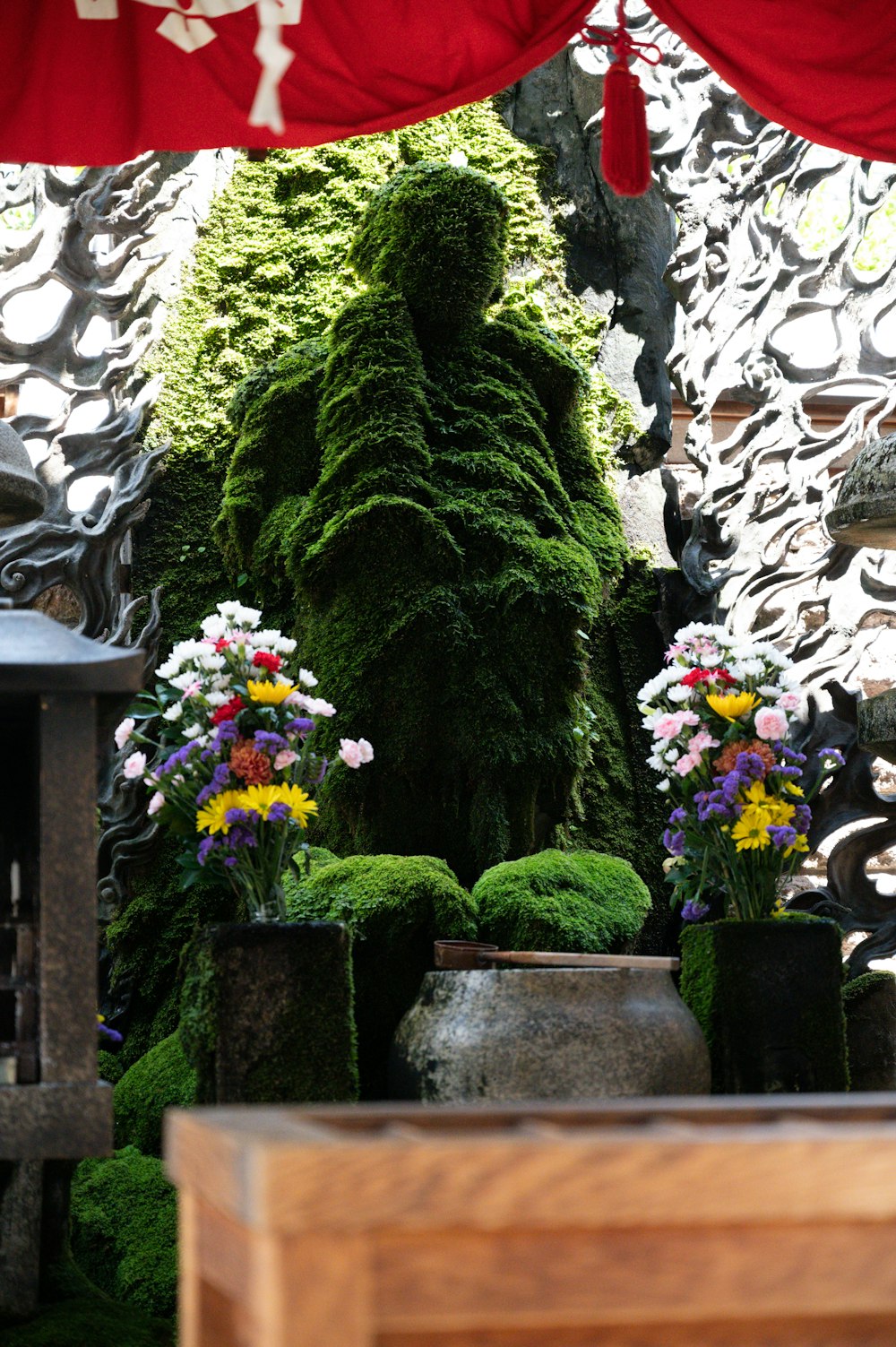 a group of vases filled with flowers next to a wall