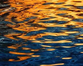 a large body of water with a yellow sky in the background