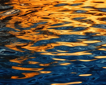 a large body of water with a yellow sky in the background