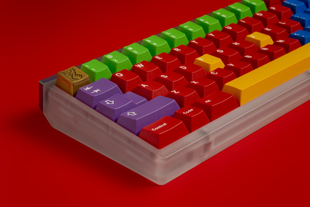 a computer keyboard with colorful keys on a red background