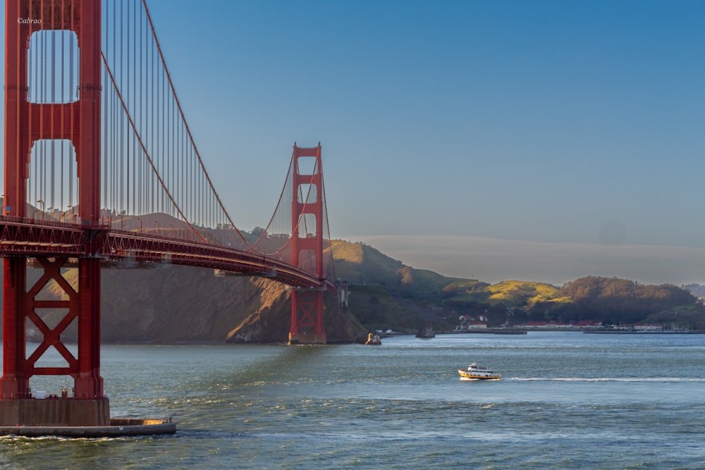 Un bateau est dans l’eau près du Golden Gate Bridge