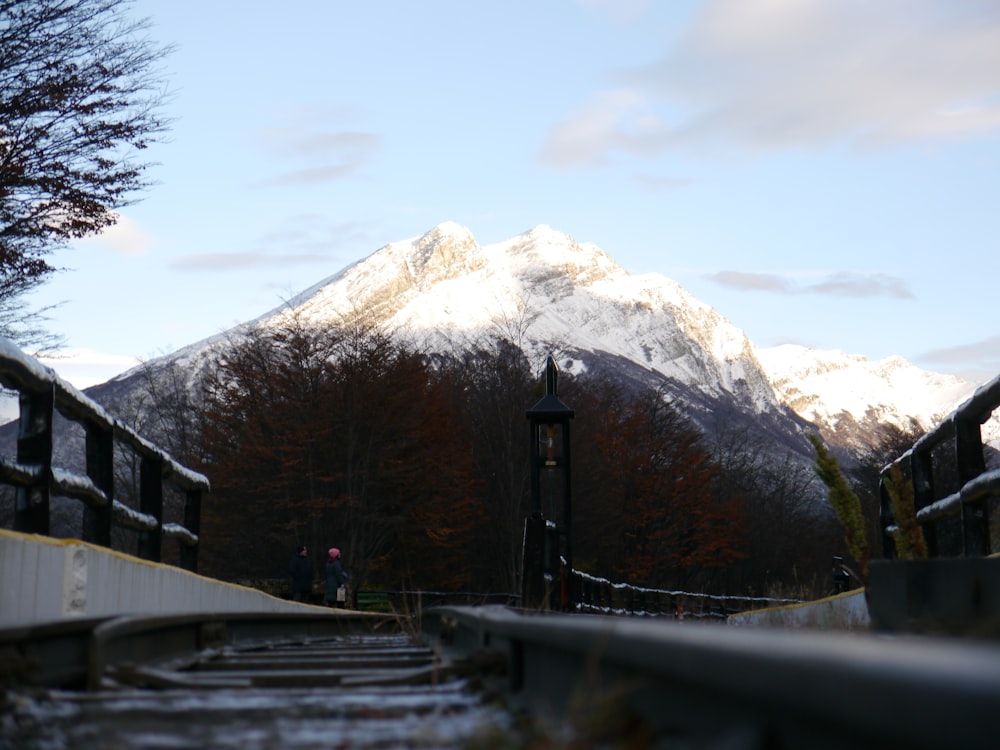 a view of a snow covered mountain from a bridge