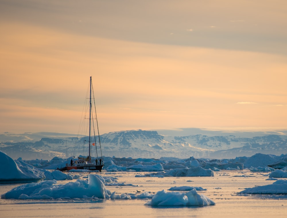 a boat in the water surrounded by icebergs