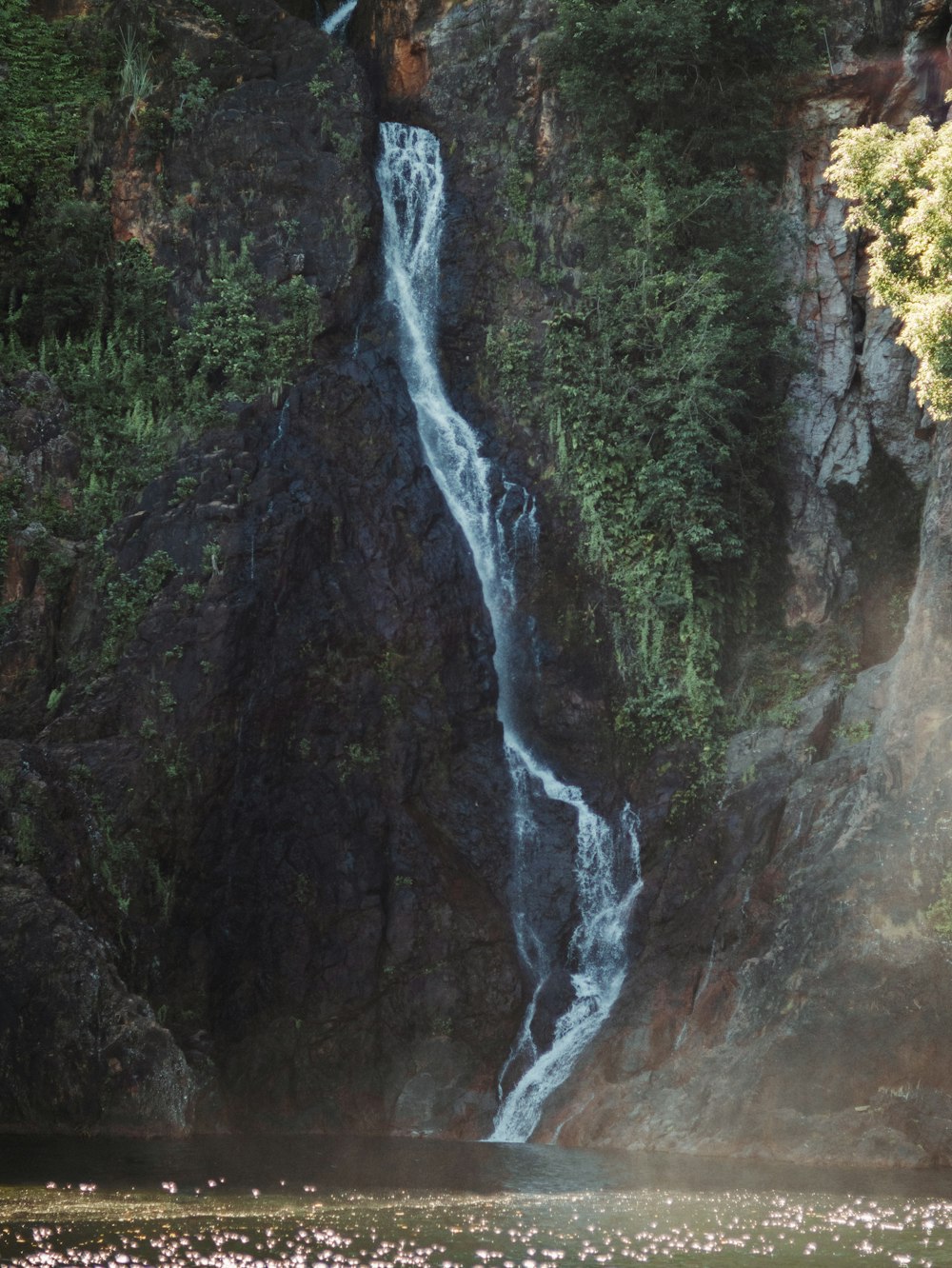 a waterfall is seen from a boat in the water