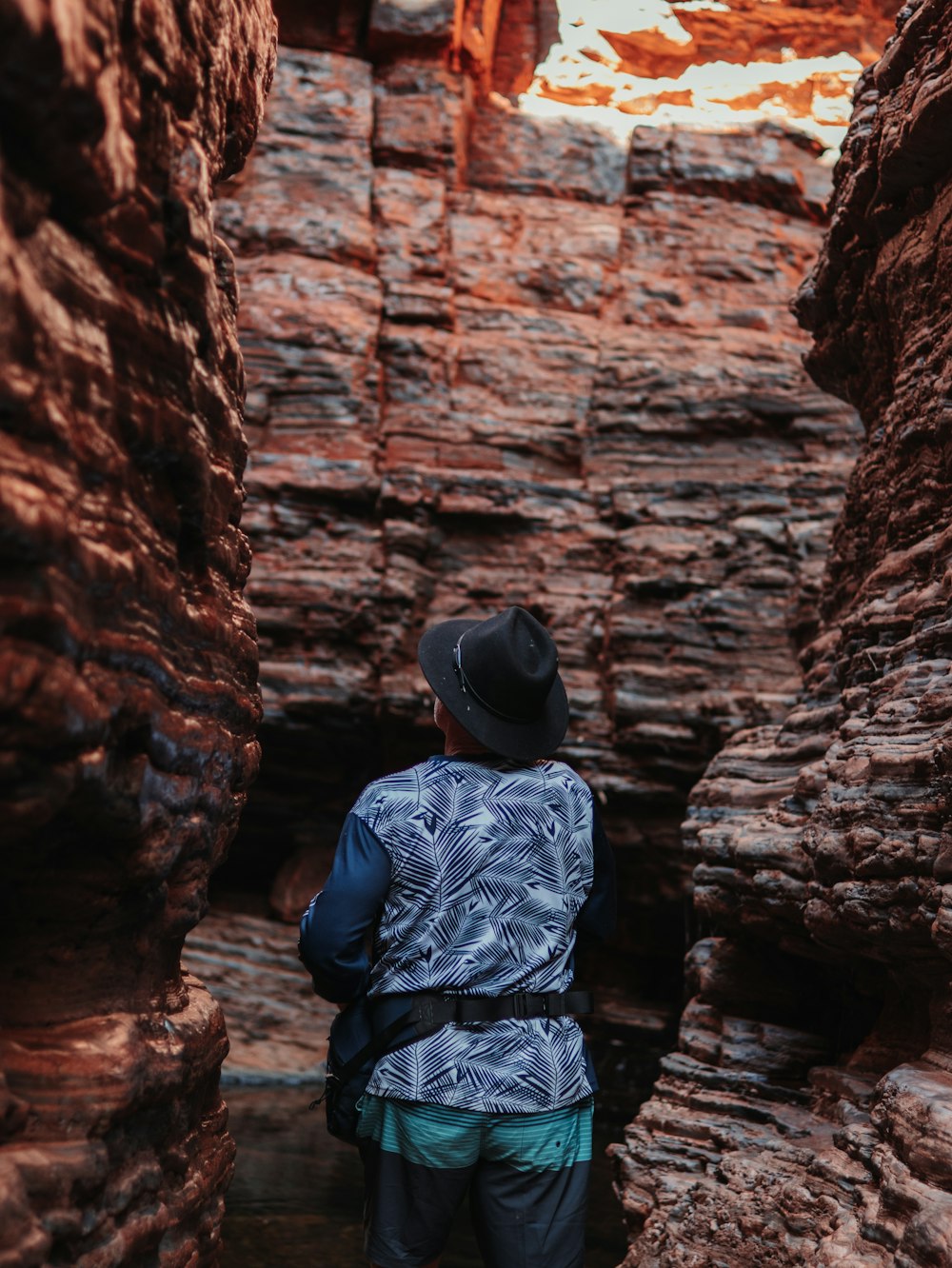 a man standing in a narrow slot in a canyon