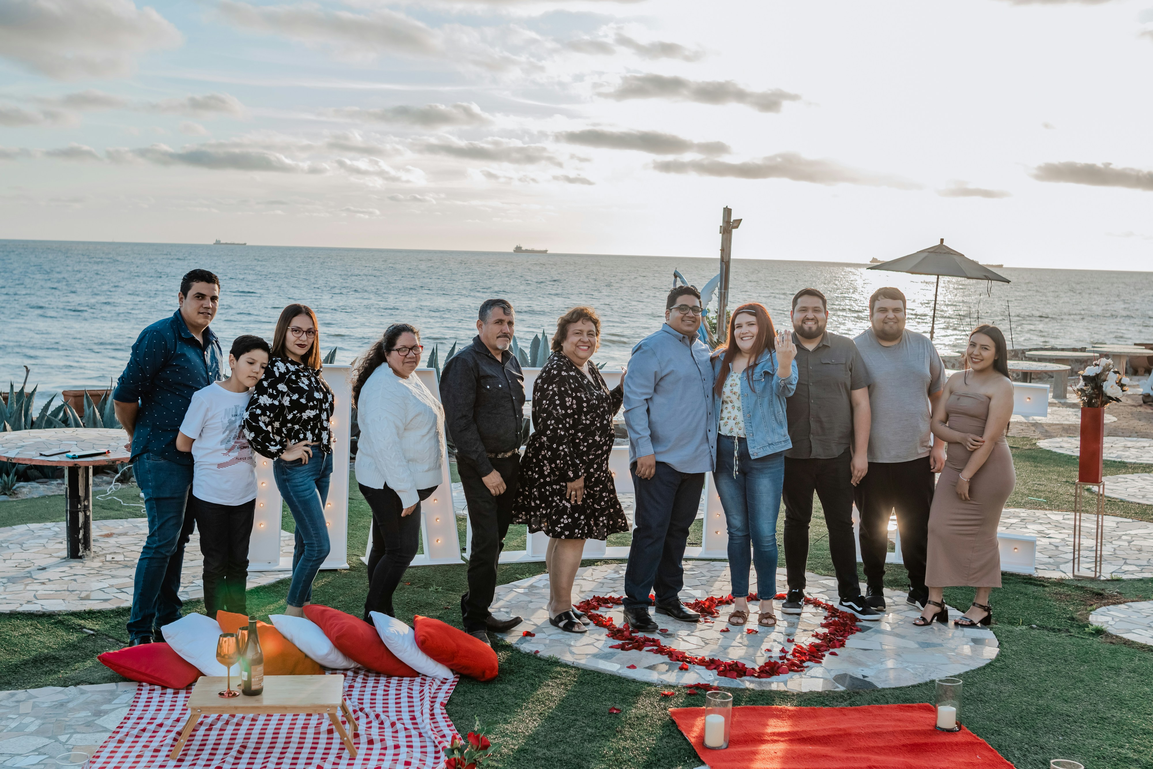 a group of people standing in front of the ocean