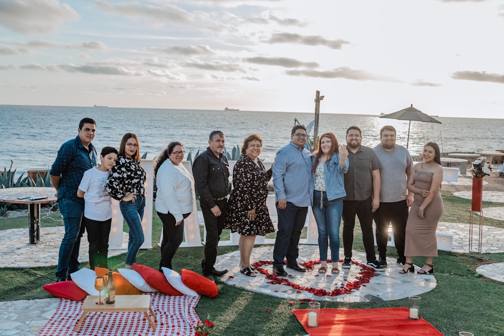 a group of people standing in front of the ocean