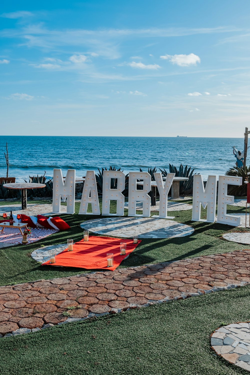 a sign that says marry me in front of the ocean
