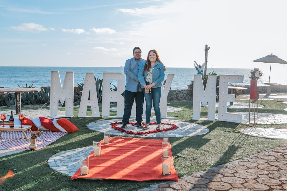 a man and woman standing in front of a welcome sign
