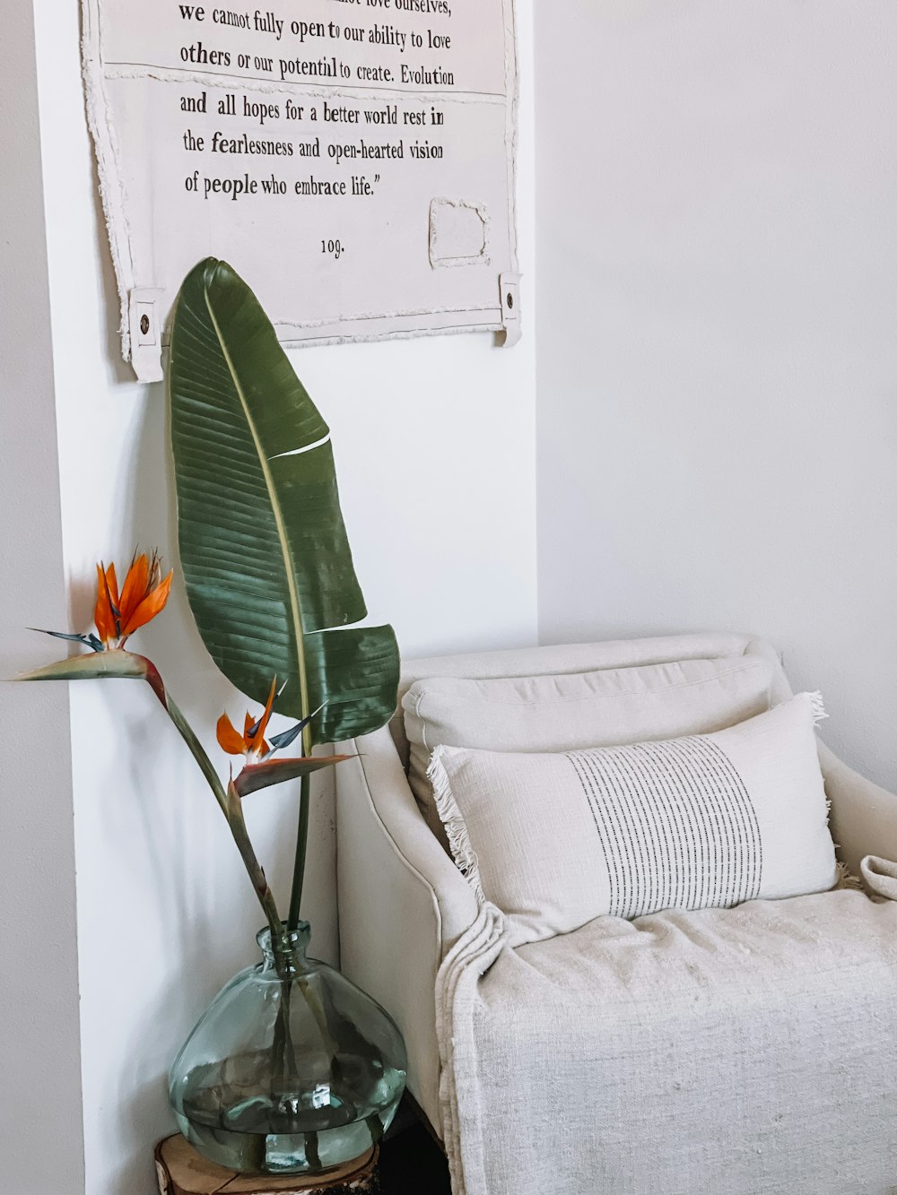 a room with a chair and a plant in a vase