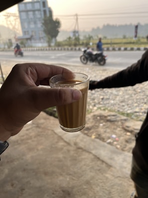 A group of travelers enjoying a roadside tea break with the car in the background.