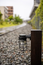 Rustic iron outdoor post light illuminating a garden path at dusk.