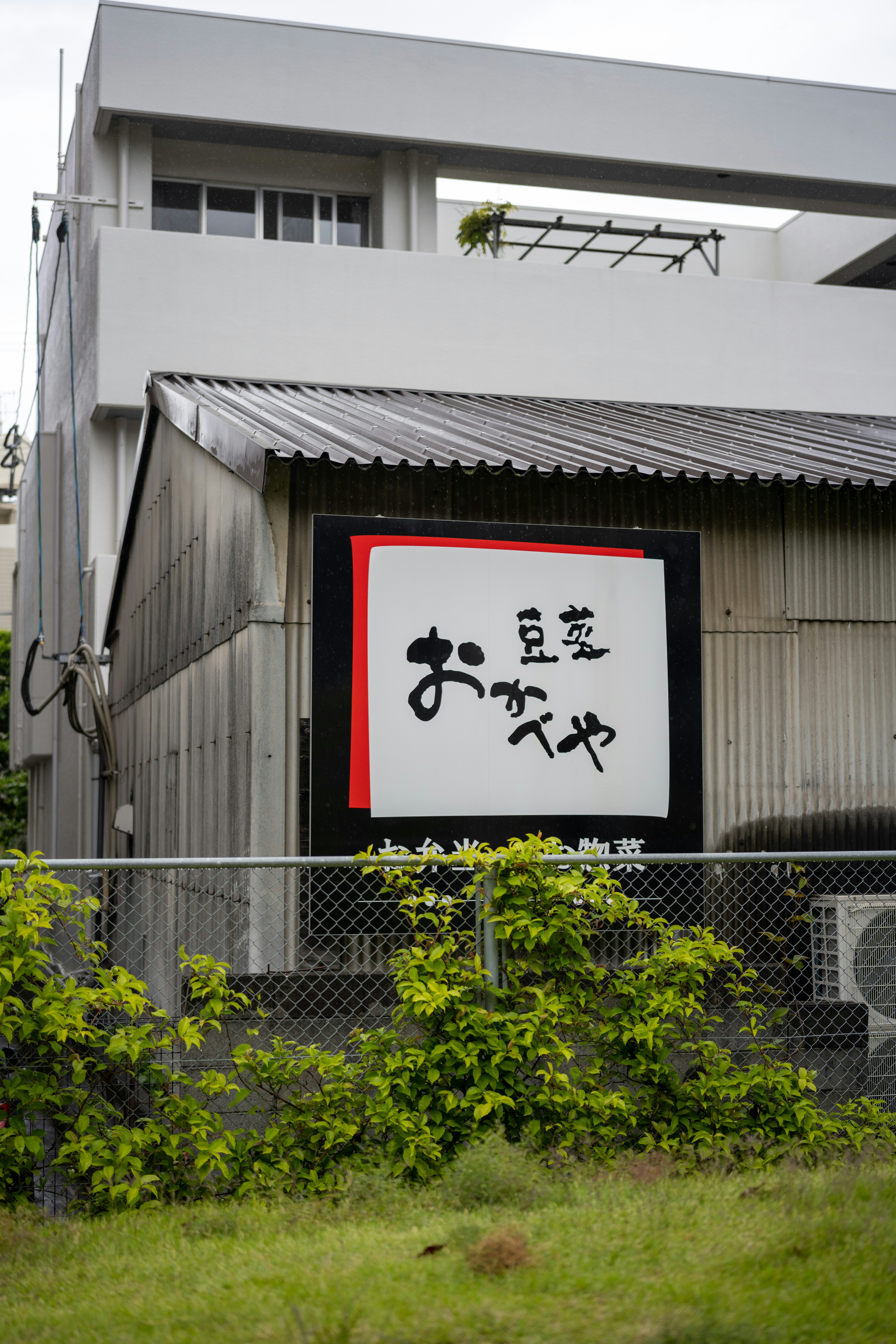 a sign on a fence in front of a building