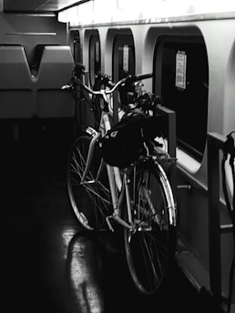 a bicycle parked next to a window on a train