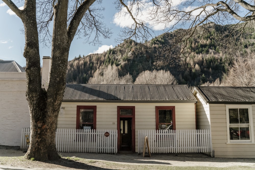 a house with a white picket fence and a mountain in the background