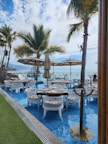 Restaurant terrace with tables set for dinner, overlooking tropical gardens.