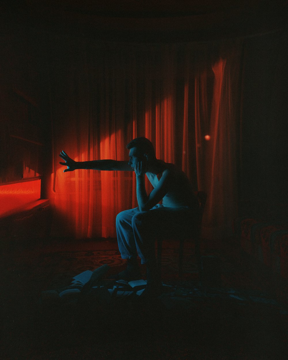 a person sitting on a chair in a dark room
