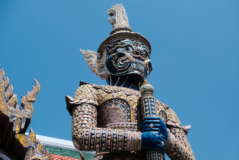 a statue of a man holding a sword in front of a blue sky