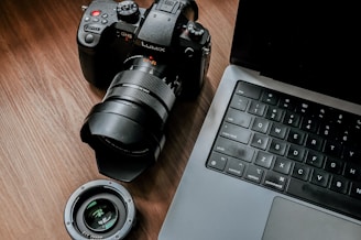 a camera sitting next to a laptop on a table