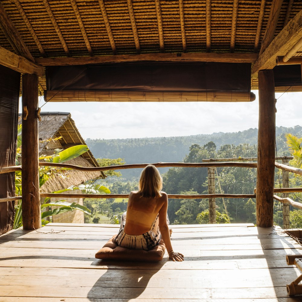 a woman is sitting on a wooden porch