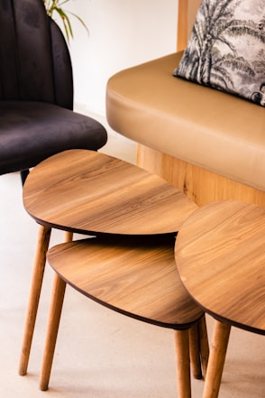 a set of three wooden tables sitting next to a couch