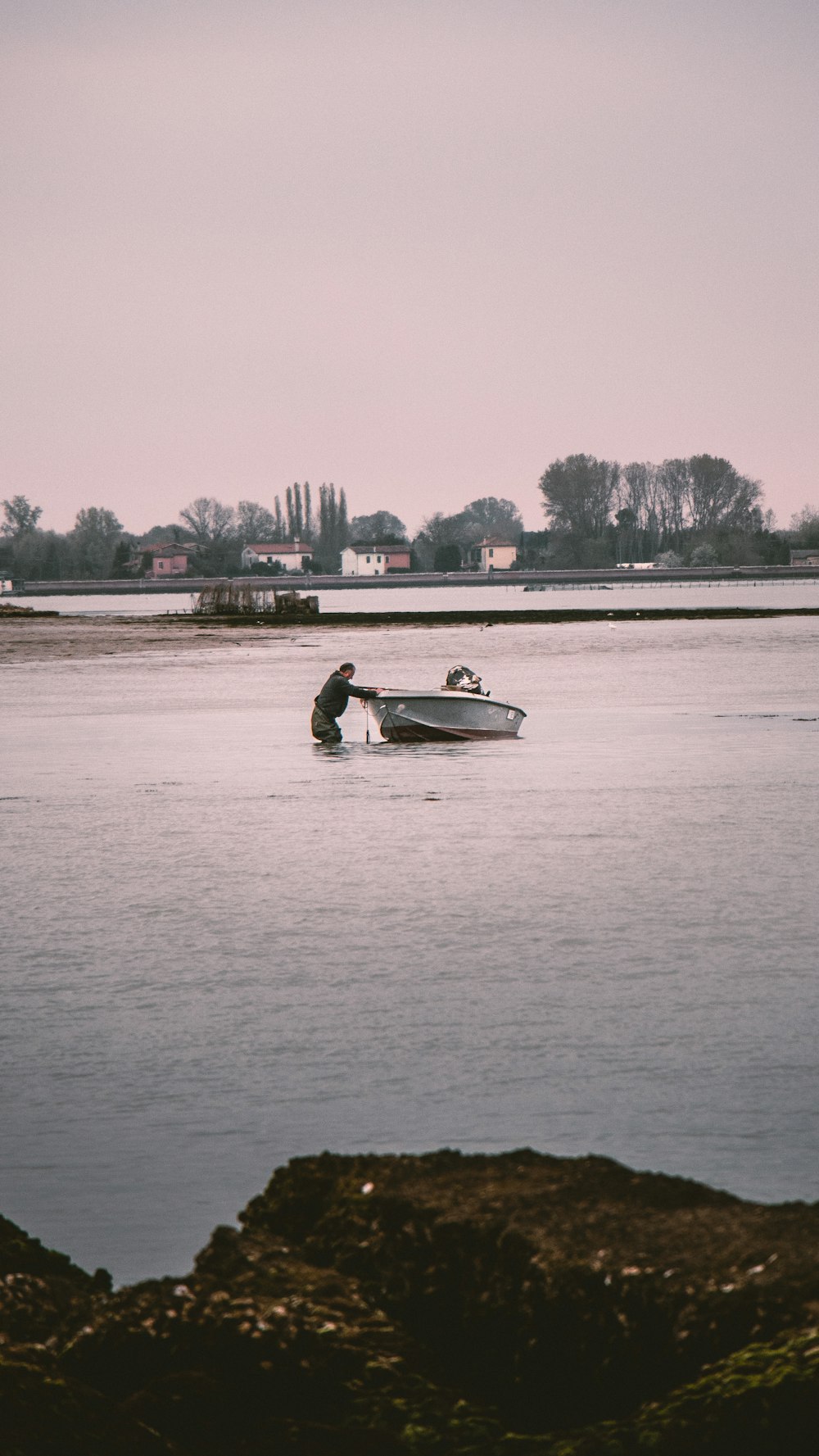 Un uomo in una barca in uno specchio d'acqua