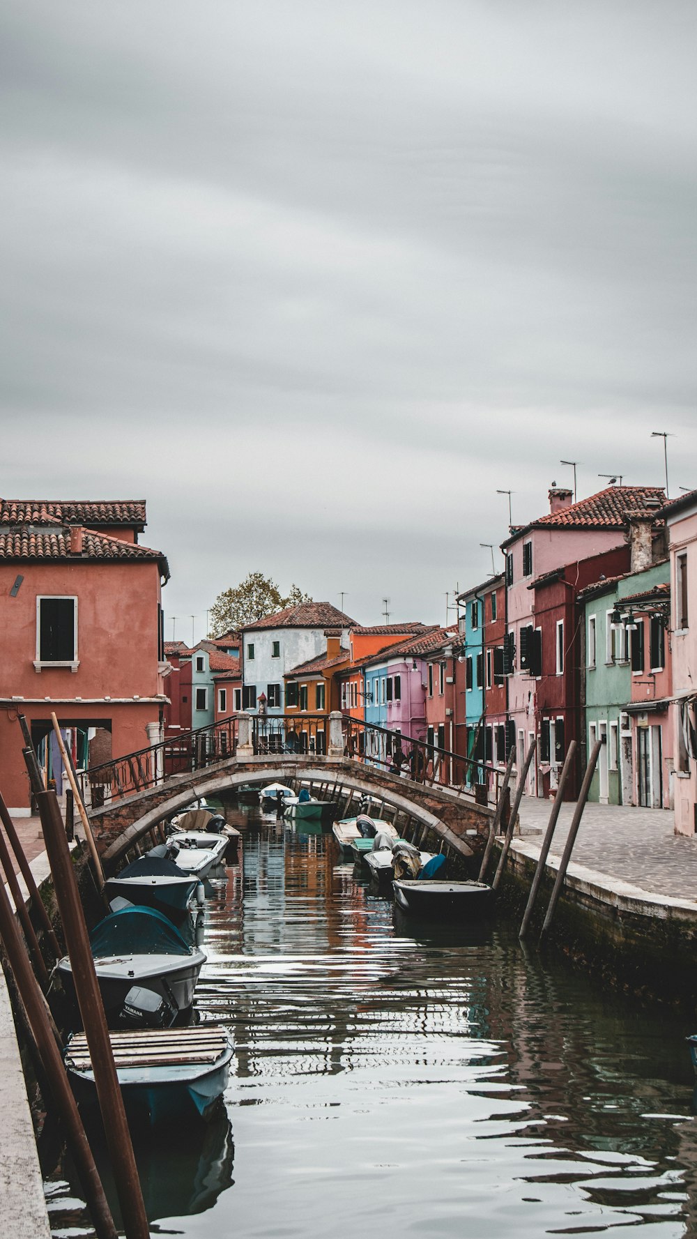 a canal filled with lots of boats next to tall buildings