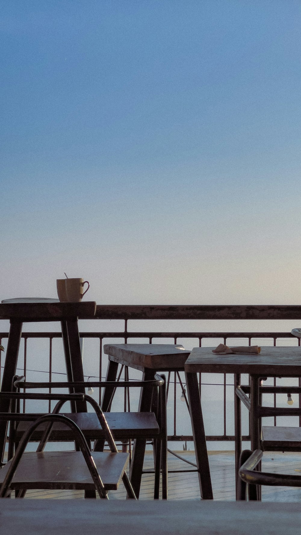 a table and chairs on a balcony overlooking the ocean