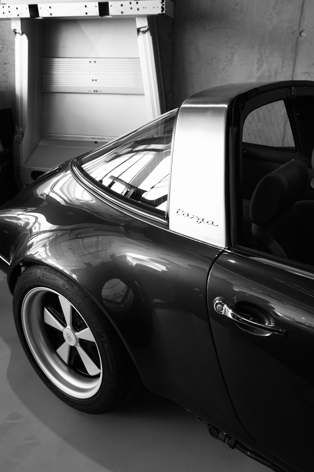 a black and white photo of a car in a garage