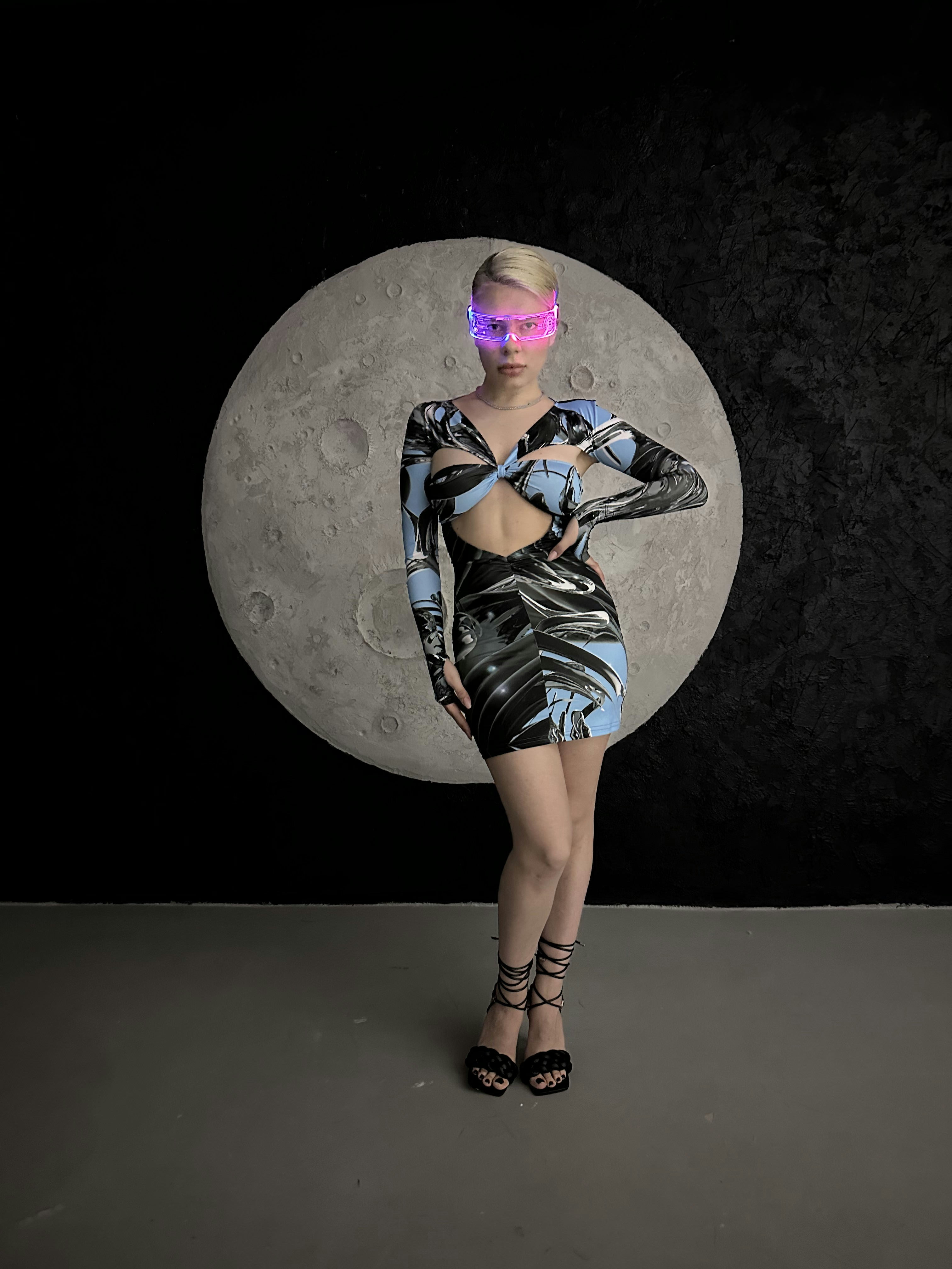 Una mujer con un vestido corto parada frente a una luna