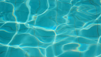 A serene image of clear blue water rippling gently under sunlight, reflecting purity and freshness.