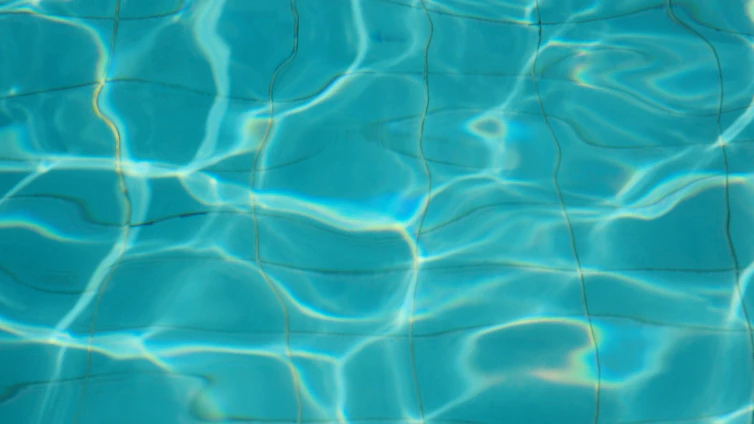 A serene image of clear blue water rippling gently under sunlight, reflecting purity and freshness.